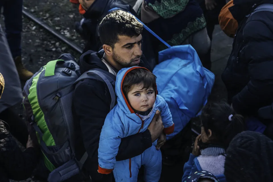 A father carries his young son off a train in Šid, Serbia, after a 15-hour ride from the Macedonian border